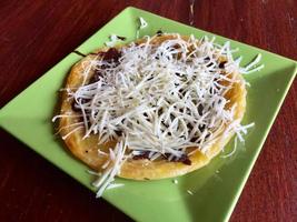 mariam bread with chocolate and cheese topping, served on a green plate photo