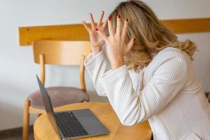 Beautiful girl freelancer feeling tired and stressed while using a laptop and working remotely from home. Business woman at the office is depressed. photo