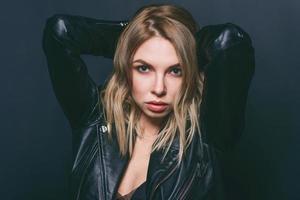 Portrait of young attractive stylish blonde woman in silk dress and black jacket on the dark background photo