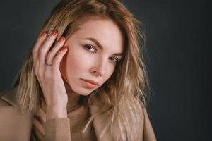 Portrait of young attractive pretty blonde woman in the beige jacket photo