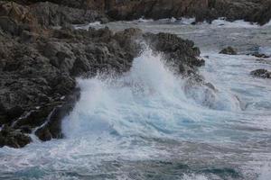 Sea reaching the rocks creating splashes of foam photo