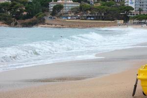 Foam from the waves as they reach the sand on the beach photo