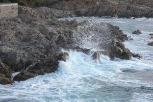 Sea reaching the rocks creating splashes of foam photo