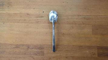 chrome spoon on isolated on the wooden table photo