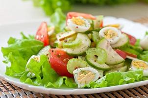 Salad of tomatoes, cucumbers and quail eggs photo