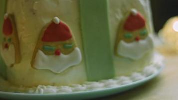 pastel de navidad con galletas de jengibre en forma de santa claus. ambiente festivo con velas y luces. video