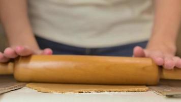 Woman kneading dough with a rolling pin for ginger cookies, closeup video