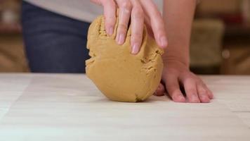 les mains d'une femme pétrissent la pâte sur la table dans la cuisine video