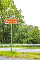 Brown-orange town sign of Pipinsburg on country road. photo