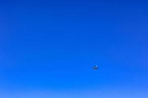 Airplane flies past clear blue sky in Germany. photo
