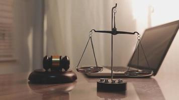 justice and law concept.Male judge in a courtroom on wooden table and Counselor or Male lawyer working in office. Legal law, advice and justice concept. video