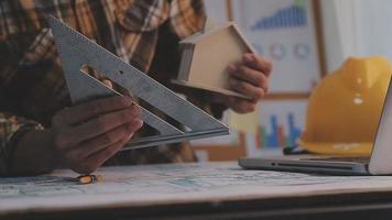 två kollegor som diskuterar databearbetning och surfplatta, bärbar dator med på arkitektoniskt projekt på byggarbetsplatsen vid skrivbordet i regeringsställning video