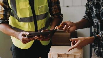 bouw ingenieur werken Bij blauwdruk naar bouwen groot reclame gebouwen in kantoor. bouwkunde gereedschap en bouw concept. video