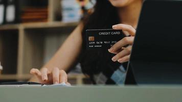 manos masculinas que sostienen una tarjeta de crédito y usan un teléfono móvil para pagar compras en línea