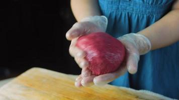 The chef spreads the green dough with a rolling pin. Tortillas prepared and decorated with spinach and beets. Red and green tortillas video