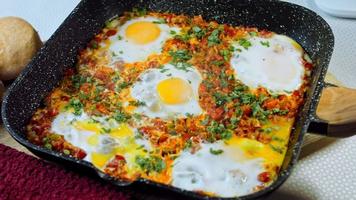 gebakken eieren in Georgisch keuken, chirbuli. eieren met tomaten stomen in de pan video