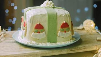 Christmas cake with gingerbread cookies in the shape of Santa Claus. Holiday atmosphere with candles and lights video