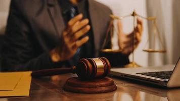 Justice and law concept.Male judge in a courtroom with the gavel, working with, computer and docking keyboard, eyeglasses, on table in morning light video