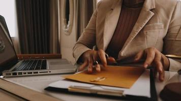 zaken en advocaten bespreken contractpapieren met koperen schaal op bureau in kantoor. wet, juridische diensten, advies, rechtvaardigheid en wet concept foto met film grain effect video