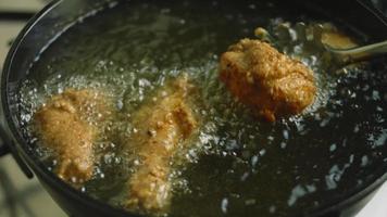 frite as pernas e asas de frango em óleo. a carne tem uma camada de farinha com especiarias video