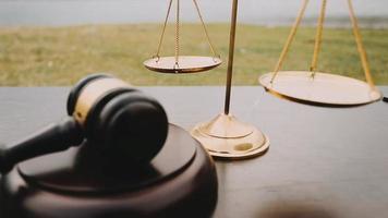 Justice and law concept.Male judge in a courtroom with the gavel, working with, computer and docking keyboard, eyeglasses, on table in morning light video