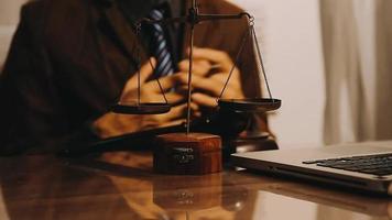 Justice and law concept.Male judge in a courtroom with the gavel, working with, computer and docking keyboard, eyeglasses, on table in morning light video