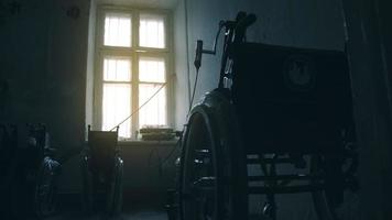 vue latérale d'un ouvrier américain dans un atelier d'une usine de fabrication de fauteuils roulants, assis sur un établi à l'aide d'outils à main et assemblant des pièces d'un produit, assis dans des fauteuils roulants