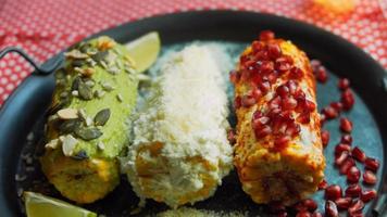 Mexican corn elote in three ways. Pressed with cheese, guacamole and pomegranate. Maxican flag video