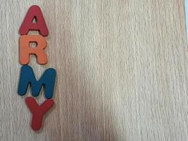 Photo of the alphabet on a wooden table that says ARMY.