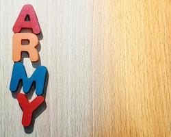 Photo of the alphabet on a wooden table that says ARMY.