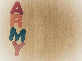 Photo of the alphabet on a wooden table that says ARMY.