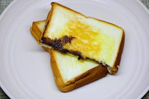 Selective focus of brown toast on pink plate with flower decoration. photo