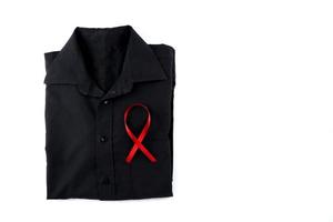 Red ribbon on a black shirt on a white background. Modern treatment and healthcare. AIDS awareness concept. photo