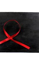 red aids ribbon on old wood background photo