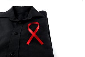 Red ribbon on a black shirt on a white background. Modern treatment and healthcare. AIDS awareness concept. photo