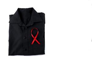 Red ribbon on a black shirt on a white background. Modern treatment and healthcare. AIDS awareness concept. photo