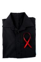 Red ribbon on a black shirt on a white background. Modern treatment and healthcare. AIDS awareness concept. photo