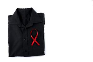 Red ribbon on a black shirt on a white background. Modern treatment and healthcare. AIDS awareness concept. photo