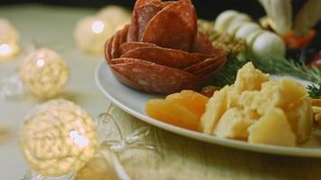 Flat charcuterie with salami, different kinds of cheese. It has dried fruits, various nuts and honey. Holiday arrangement with burning candles video