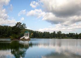 A small beautiful island on Lake Aya in the Altai Territory or the Altai Republic. There is a small gazebo on the island and a forest around the lake. photo