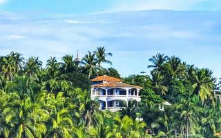 Hotels resorts buildings in paradise among palm trees Puerto Escondido. photo