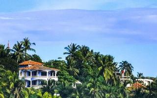 Hotels resorts buildings in paradise among palm trees Puerto Escondido. photo