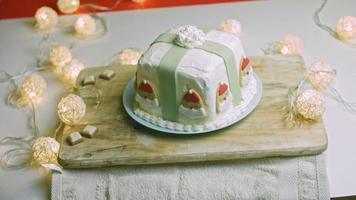 Christmas cake with gingerbread cookies in the shape of Santa Claus. Holiday atmosphere with candles and lights