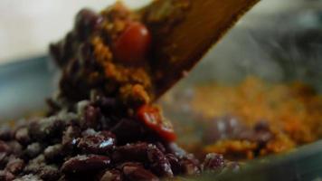mélanger les ingrédients pour le chorizo et les tomates confites avec une cuillère en bois. prise de vue macro video