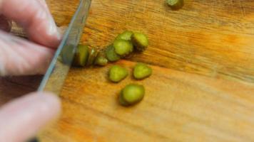 The chef cuts small pickled cucumbers into slices video