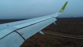 View of the wing of the aircraft from the window. Airliner arrived at the airport, landing video