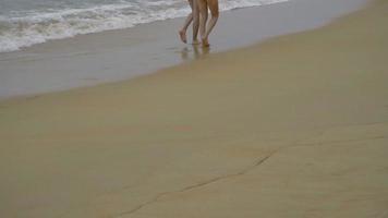 Couple walking barefoot on wet sand Similan island beach video