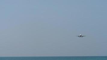 el avión se acerca para aterrizar sobre el océano en tailandia. concepto de turismo video