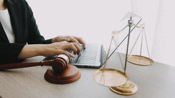 Justice and law concept.Male judge in a courtroom with the gavel, working with, computer and docking keyboard, eyeglasses, on table in morning light video