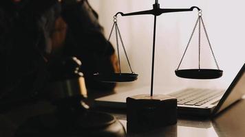Justice and law concept.Male judge in a courtroom with the gavel, working with, computer and docking keyboard, eyeglasses, on table in morning light video